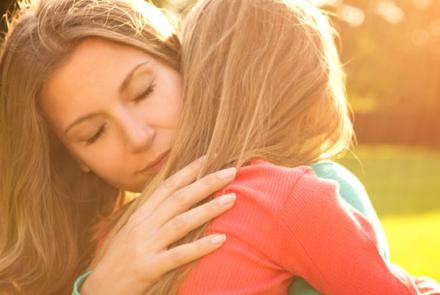 woman embracing girl